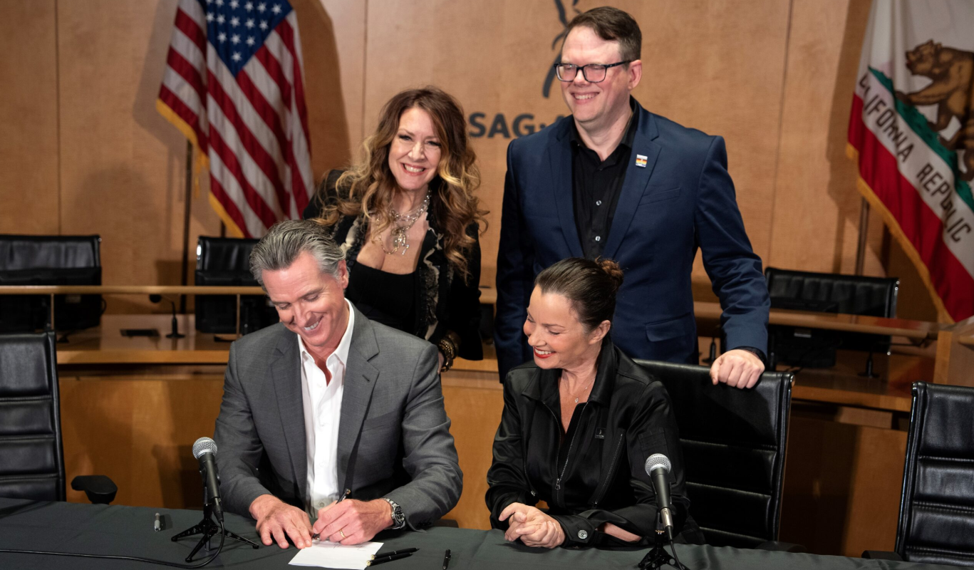 California Governor Gavin Newsome signing one of several new AI laws; public domain photo by the State of California